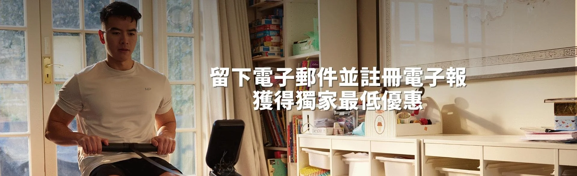 A man workout out on a rowing machine at home with the words 'You're Already Ready - MYPROTEIN' overlaying.